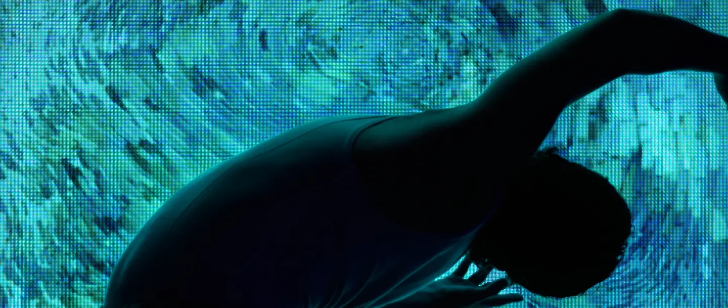 Silhouette against digital imagery of ocean like swirls